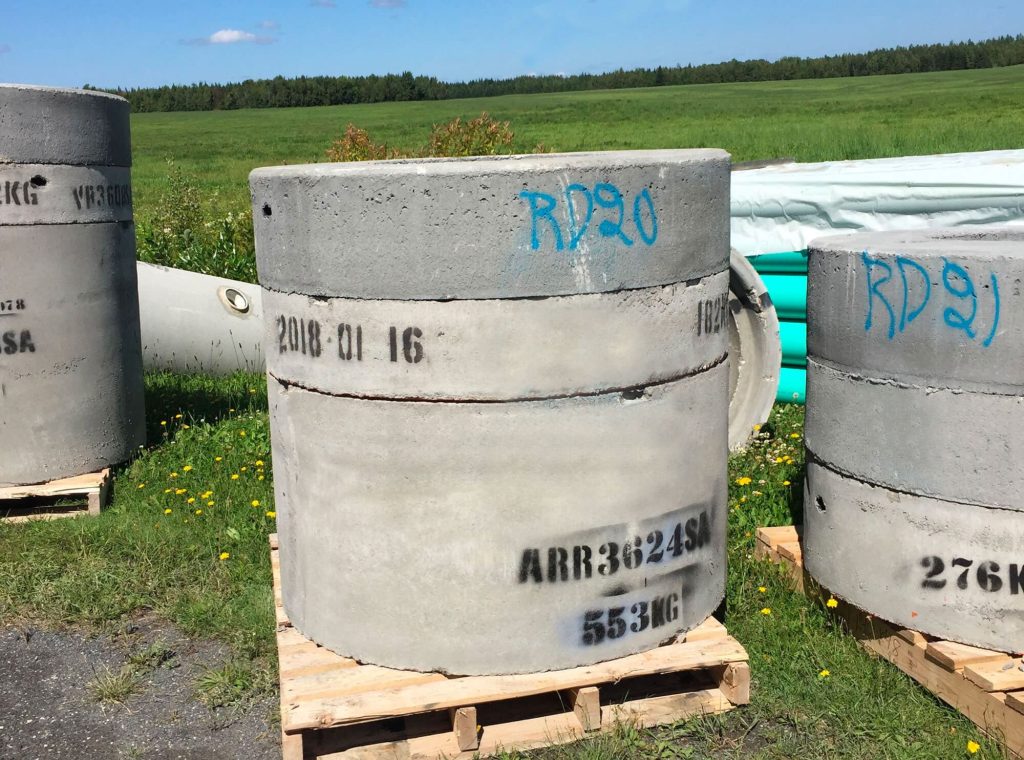 Tuyaux de béton empilés sur palettes à extérieur