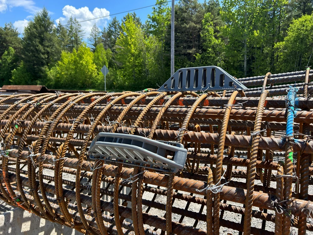 Rusty rebar cage with gray safety spacers outdoors