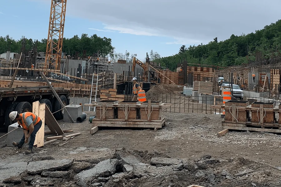 Chantier de construction avec travailleurs et équipements.