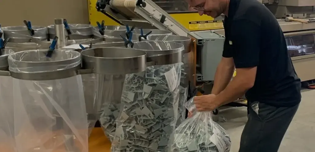 Manœuvre qui ferme un sac en plastique contenant des produits Plasti-Tom.